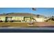Single-story home with green exterior, landscaped yard, and paved driveway at 906 Bluewater Dr, Sun City Center, FL 33573
