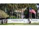 Peppertree Village Condominiums entrance sign with palm trees and American and community flags at 11410 8Th N Way # 310, St Petersburg, FL 33716