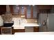 Modern kitchen with stainless steel appliances, wood cabinets, stylish backsplash, and a farmhouse sink at 11410 8Th N Way # 310, St Petersburg, FL 33716