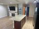 Spacious living room featuring a fireplace, TV, open shelving, and island with a light countertop at 11410 8Th N Way # 310, St Petersburg, FL 33716