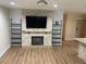 Cozy living room featuring fireplace, shelving, neutral color walls, and hardwood-style flooring at 11410 8Th N Way # 310, St Petersburg, FL 33716