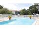Community pool with clear blue water, surrounded by lush landscaping and comfortable lounge chairs at 11410 8Th N Way # 310, St Petersburg, FL 33716