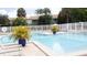 Community pool with clear blue water, surrounded by lush landscaping and comfortable lounge chairs at 11410 8Th N Way # 310, St Petersburg, FL 33716