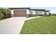 Modern single-story home with brown garage door and landscaped lawn at 16229 Cape Horn Blvd, Punta Gorda, FL 33955