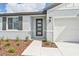 Front entry of a home with dark-gray door, shutters and walkway at 14006 Ginnie Springs Way, Parrish, FL 34219