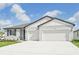 Two-story home with light-gray exterior, two-car garage and neatly landscaped yard at 14006 Ginnie Springs Way, Parrish, FL 34219