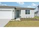 Newly built light green house with a two-car garage and front yard at 14022 Ginnie Springs Way, Parrish, FL 34219