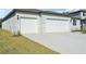 Two-car garage with white doors and a concrete driveway at 14022 Ginnie Springs Way, Parrish, FL 34219