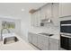 Modern kitchen with gray cabinets, quartz countertops, and stainless steel appliances at 14022 Ginnie Springs Way, Parrish, FL 34219