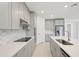 Modern kitchen with gray cabinets, quartz countertops, and stainless steel appliances at 14022 Ginnie Springs Way, Parrish, FL 34219