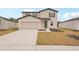 Two-story house with a light beige exterior, gray door, and two-car garage at 144 Lazy Shore Dr, Nokomis, FL 34275