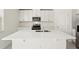 Modern kitchen with white cabinets and a large island at 144 Lazy Shore Dr, Nokomis, FL 34275