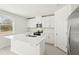 Modern kitchen with white cabinets and a large island at 144 Lazy Shore Dr, Nokomis, FL 34275