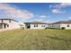 Large backyard with grassy area and new construction homes in the background at 169 Lazy Shore Dr, Nokomis, FL 34275