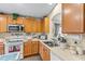 View of kitchen with wood cabinets, stainless steel appliances, and ample counter space at 7851 Tuscany Woods Dr, Tampa, FL 33647