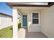 Quaint front entry with teal door and a covered porch at 14040 Crutchfield Ct, Parrish, FL 34219