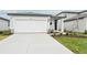 Front view of a house with a white garage door and landscaping at 14052 Crutchfield Ct, Parrish, FL 34219