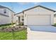 One-story home with white exterior, two-car garage, and landscaping at 14053 Crutchfield Ct, Parrish, FL 34219