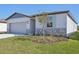 Single-story home with gray siding, stone accents, and a two-car garage. Landscaped yard at 7806 Gilchrist Springs Dr, Parrish, FL 34219