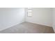 An empty bedroom with beige carpet, white walls, and a window offering natural light at 7818 Gilchrist Springs Dr, Parrish, FL 34219