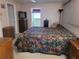 Cozy bedroom features a colorful patterned bedspread, dresser, and adjoining bathroom at 2587 Blackwood Cir, Clearwater, FL 33763