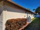 View of the home's side, highlighting the landscaping, clear skies, and central air conditioning at 2587 Blackwood Cir, Clearwater, FL 33763