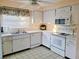 Well-lit kitchen boasts white cabinets and appliances, set against tiled flooring at 2587 Blackwood Cir, Clearwater, FL 33763