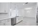 Kitchen island with sink and dishwasher, white cabinets, and light flooring at 16093 Ivy Ridge Ct, Port Charlotte, FL 33953