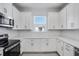 White kitchen cabinets, stainless steel appliances, and white countertops at 16093 Ivy Ridge Ct, Port Charlotte, FL 33953