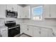 White kitchen cabinets, stainless steel appliances, and white countertops at 16093 Ivy Ridge Ct, Port Charlotte, FL 33953