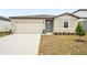 Tan house with a two-car garage and teal front door at 31650 Malbec Dr, Brooksville, FL 34602