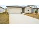 Tan house with a two-car garage and a well-manicured lawn at 31650 Malbec Dr, Brooksville, FL 34602