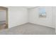 Simple bedroom with carpet, window, and door to another room at 31698 Wild Grape Ln, Brooksville, FL 34602