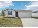One story home with gray siding, two car garage, and landscaped lawn at 31698 Wild Grape Ln, Brooksville, FL 34602