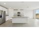 Modern kitchen with white cabinets, granite island, and stainless steel appliances at 31698 Wild Grape Ln, Brooksville, FL 34602