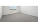 Spacious bedroom with grey carpet and large window at 31703 Wild Grape Ln, Brooksville, FL 34602
