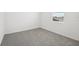 Simple bedroom with gray carpeting and window at 31703 Wild Grape Ln, Brooksville, FL 34602