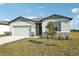 One-story house with gray siding, stone accents, and a two-car garage at 31703 Wild Grape Ln, Brooksville, FL 34602