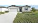 Curb appeal! A charming one-story house with gray siding, stone accents, and a two-car garage at 31703 Wild Grape Ln, Brooksville, FL 34602