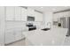 Bright kitchen boasts white cabinets, stainless steel appliances, and a large kitchen island at 31703 Wild Grape Ln, Brooksville, FL 34602
