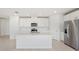Modern kitchen with island, stainless steel appliances, and white shaker cabinets at 31703 Wild Grape Ln, Brooksville, FL 34602