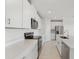 Modern kitchen featuring white cabinets, stainless steel appliances, and quartz countertops at 31703 Wild Grape Ln, Brooksville, FL 34602