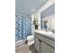 Clean bathroom with gray vanity and blue shower curtain at 7729 Rosewood Garden Loop, Tampa, FL 33637