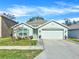 Single-story home with green accents and a two-car garage at 7729 Rosewood Garden Loop, Tampa, FL 33637