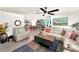 Open living room with sectional sofa, coffee table, and kitchen view at 7729 Rosewood Garden Loop, Tampa, FL 33637