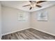 Bright bedroom with wood-look floors and two windows with blinds at 7311 Buchanan Dr, Port Richey, FL 34668
