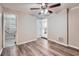 Spacious bedroom with wood-look floors, ceiling fan, and access to the bathroom at 7311 Buchanan Dr, Port Richey, FL 34668