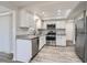Modern kitchen with white cabinets, granite countertops, and stainless steel appliances at 7311 Buchanan Dr, Port Richey, FL 34668