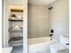 Modern bathroom with a bathtub, open shelving and patterned floor at 7384 Van Lake Dr, Englewood, FL 34224