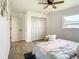 Bright bedroom with ceiling fan, double doors, and wood flooring at 7384 Van Lake Dr, Englewood, FL 34224